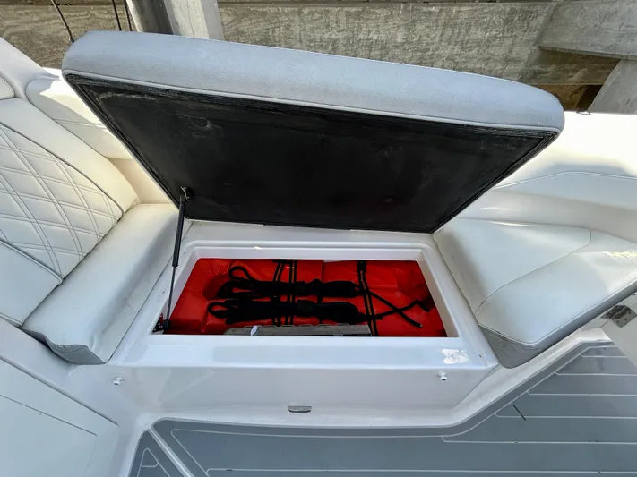 All Gas No Brakes Yacht Photos Pics 2020 Regal 33 SAV boat seat storage compartment with open lid, revealing red interior.