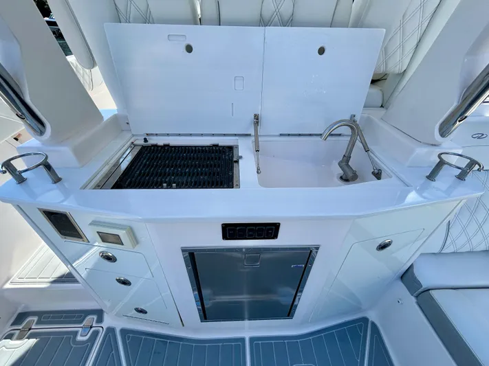 All Gas No Brakes Yacht Photos Pics 2020 Regal 33 SAV boat kitchen with grill, sink, and storage.