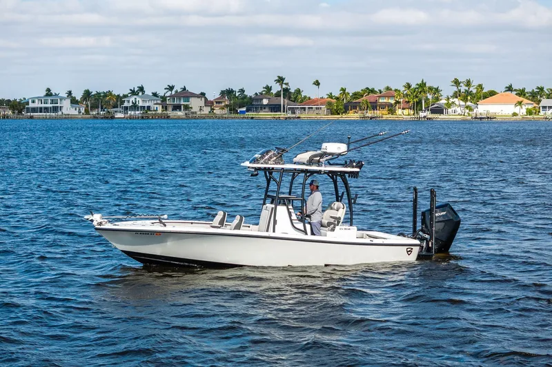  Yacht Photos Pics 2021 Barker Boatworks 26 Open cruising on a scenic waterfront with houses in the background.