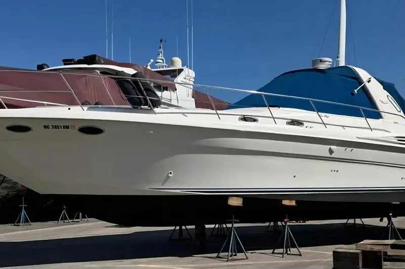  Yacht Photos Pics 1997 Sea Ray Sundancer 400 yacht on stands, with blue canopy, in a marina setting.