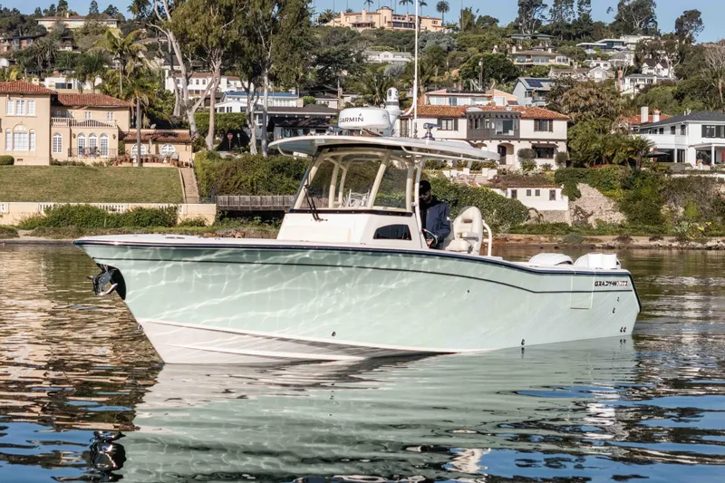  Yacht Photos Pics 2022 Grady-White Canyon 306 boat on calm water near luxury waterfront homes.