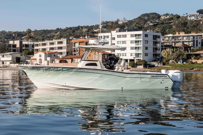  Yacht Photos Pics 2022 Grady-White Canyon 306 boat on calm water near coastal buildings.