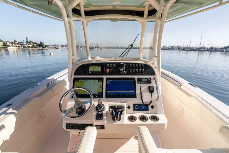  Yacht Photos Pics 2022 Grady-White Canyon 306 boat cockpit with advanced navigation system on calm water.
