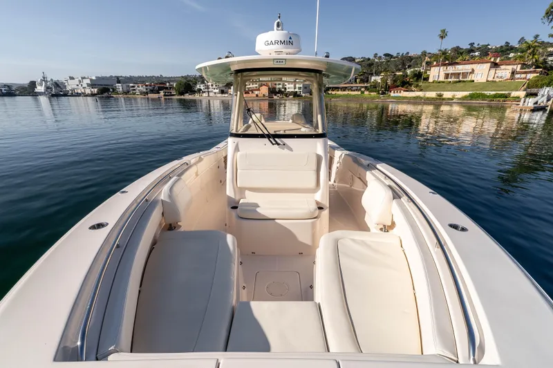  Yacht Photos Pics 2022 Grady-White Canyon 306 boat on calm water, featuring spacious seating and Garmin equipment.