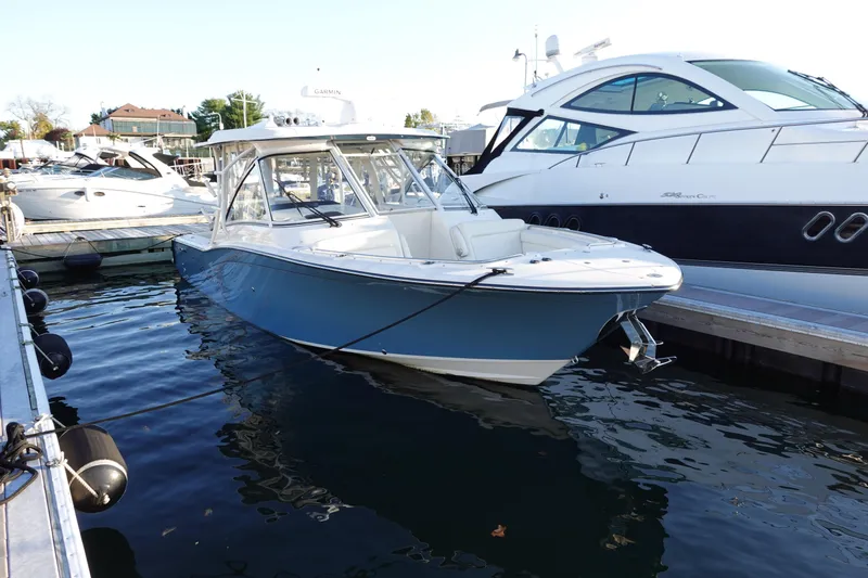  Yacht Photos Pics 2021 Grady-White Freedom 325 boat docked at marina, surrounded by other vessels.