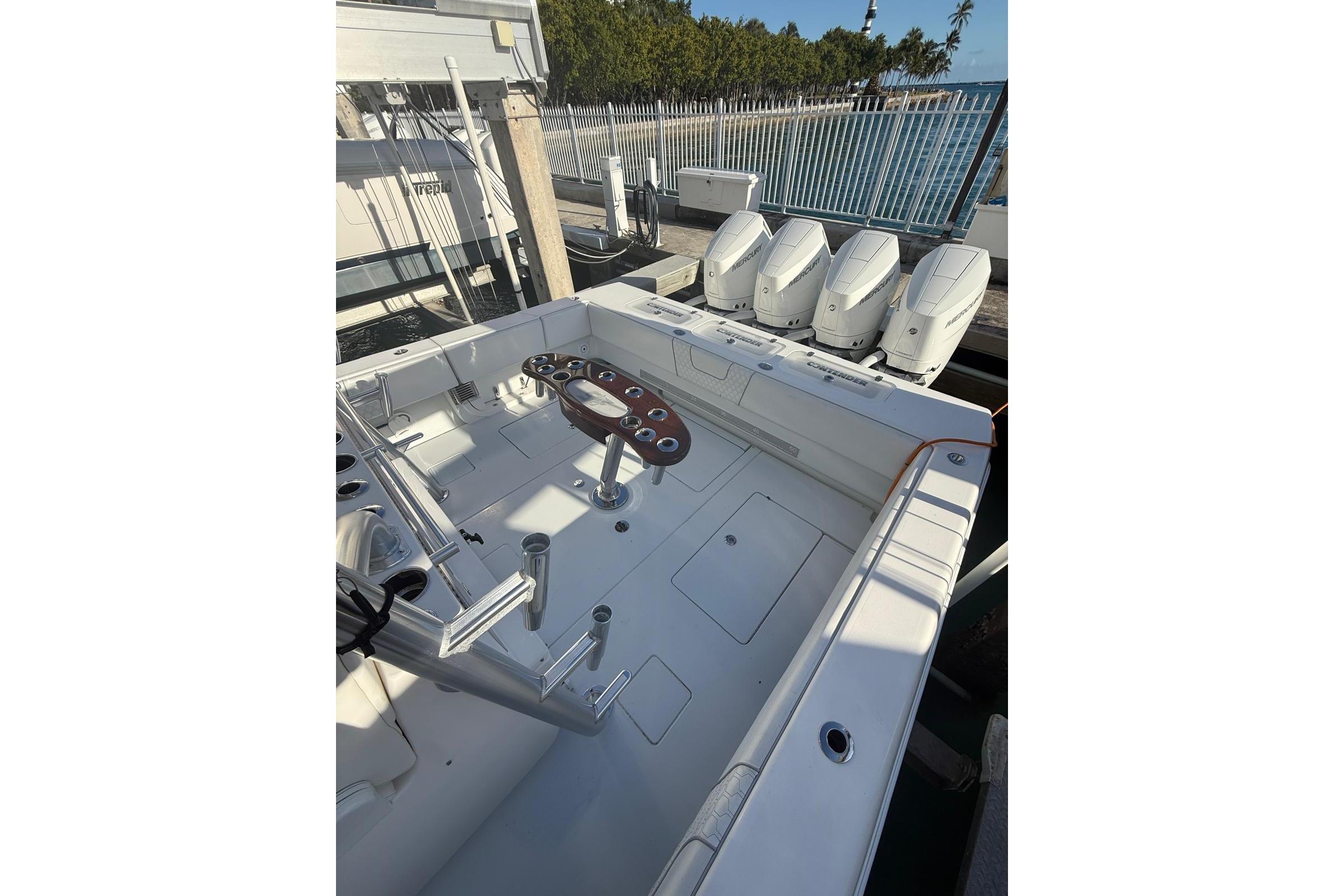 2024 Contender 44 ST boat with quad engines, spacious deck, and fishing rod holders.