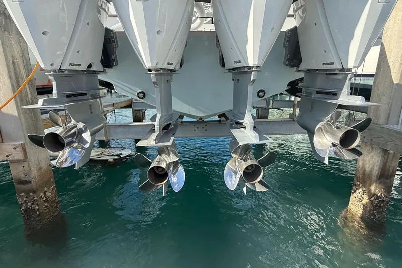 Scott Free Yacht Photos Pics 2024 Contender 44 ST boat with four powerful outboard engines and propellers at a dock.