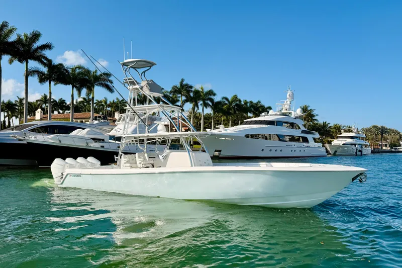 Scott Free Yacht Photos Pics 2024 Contender 44 ST boat docked in a marina with palm trees and yachts.