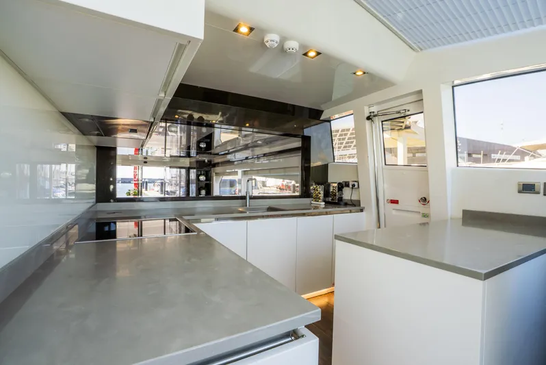 Omnia Yacht Photos Pics Modern kitchen interior on a 2018 Pearl 80 yacht, featuring sleek countertops and ample natural light.