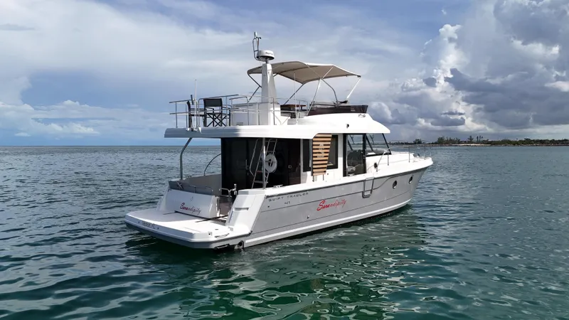 Sarandipity Yacht Photos Pics 2024 Beneteau Swift Trawler 41 Fly cruising on calm waters under a cloudy sky.