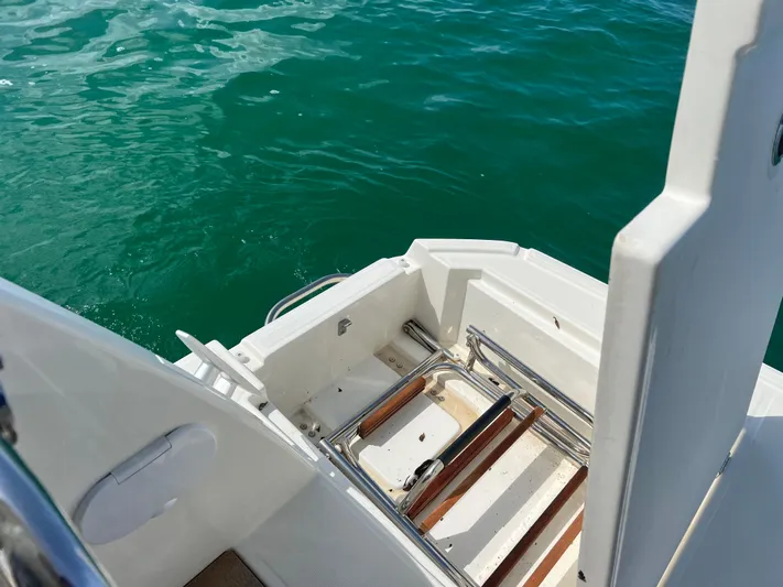 Sarandipity Yacht Photos Pics 2024 Beneteau Swift Trawler 41 Fly swim platform with ladder, surrounded by clear blue water.