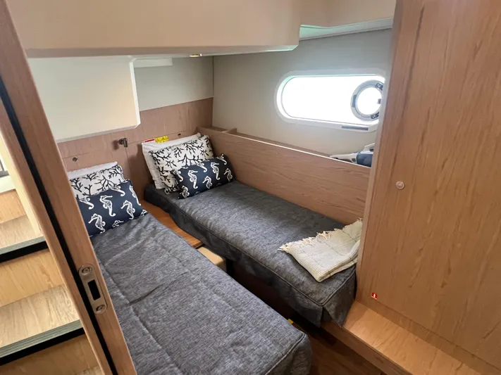 Sarandipity Yacht Photos Pics 2024 Beneteau Swift Trawler 41 Fly cabin with twin beds and nautical-themed pillows.