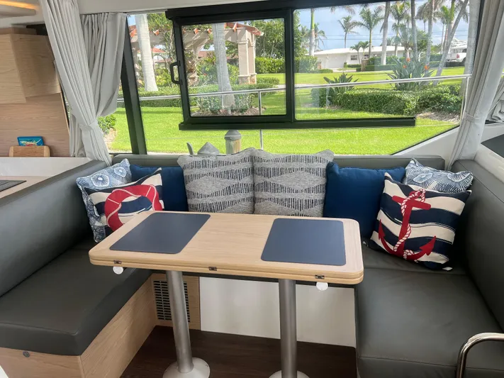 Sarandipity Yacht Photos Pics Interior of 2024 Beneteau Swift Trawler 41 Fly with nautical-themed cushions and dining area.