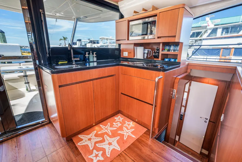 Ryan's Inheritance Yacht Photos Pics Luxurious kitchen interior of 2017 Aquila 44 Yacht with wood cabinetry and modern appliances.