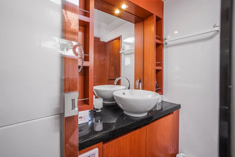 Ryan's Inheritance Yacht Photos Pics Luxurious bathroom in 2017 Aquila 44 Yacht with modern sink and wooden cabinetry.