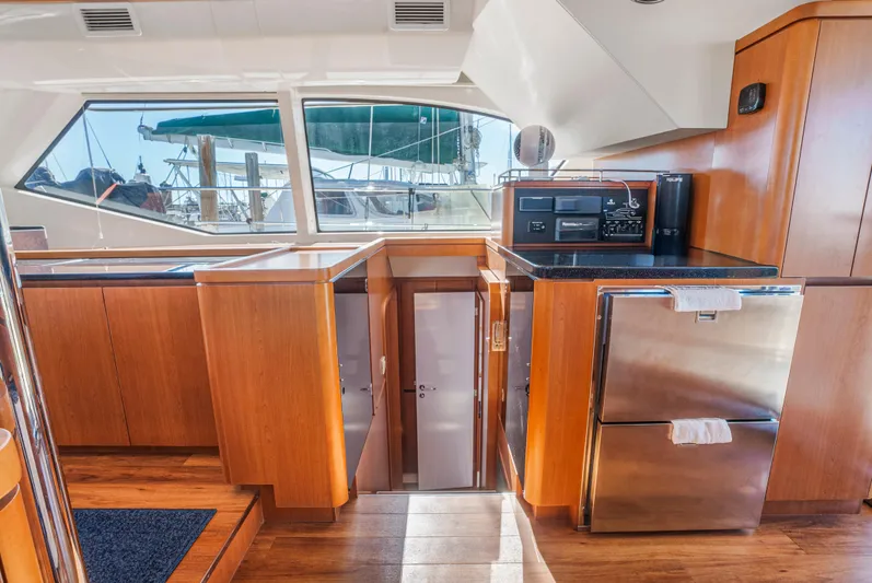 Ryan's Inheritance Yacht Photos Pics Interior of 2017 Aquila 44 Yacht with modern kitchen and wood cabinetry.