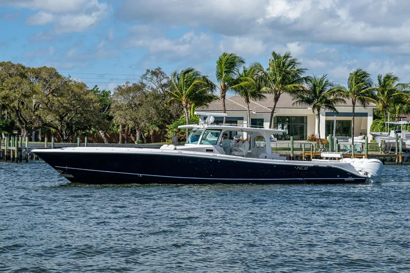  Yacht Photos Pics 2020 HCB 53 boat cruising on a sunny day near waterfront homes.