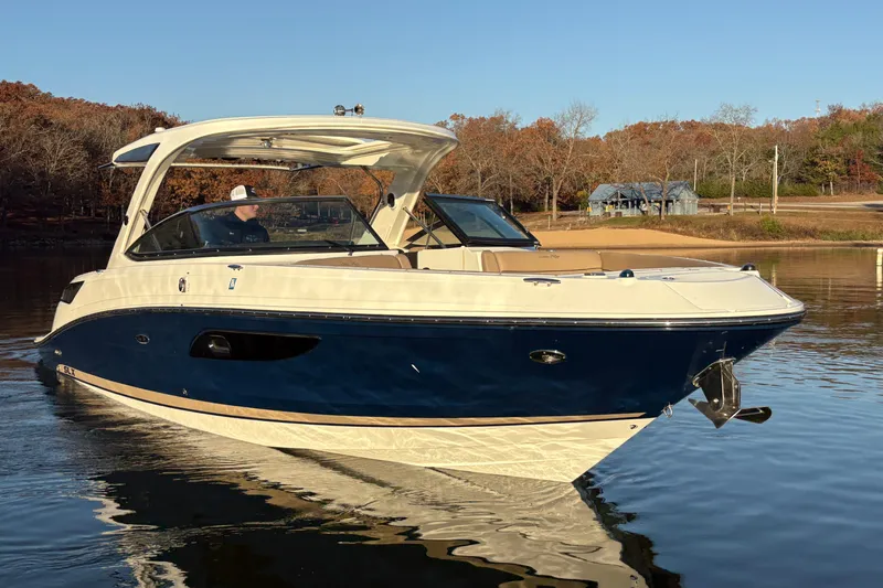  Yacht Photos Pics 2016 Sea Ray 350 SLX boat cruising on a calm lake near a wooded shoreline.