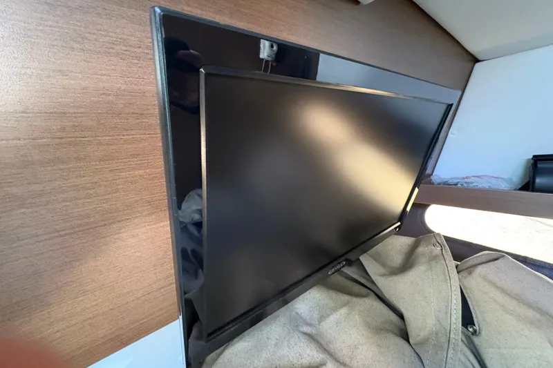  Yacht Photos Pics Flat-screen TV mounted on a wooden panel inside a 2016 Sea Ray 350 SLX boat.