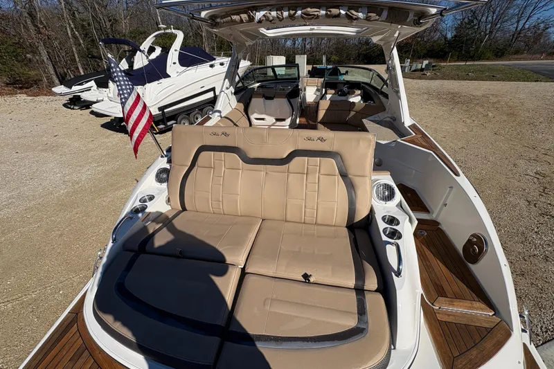  Yacht Photos Pics 2016 Sea Ray 350 SLX boat with tan seating and American flag, parked on gravel.