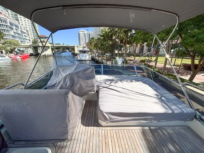 Micky's Dream Yacht Photos Pics 2020 Greenline 45 Fly yacht deck with covered seating and sunbed, docked by waterfront.