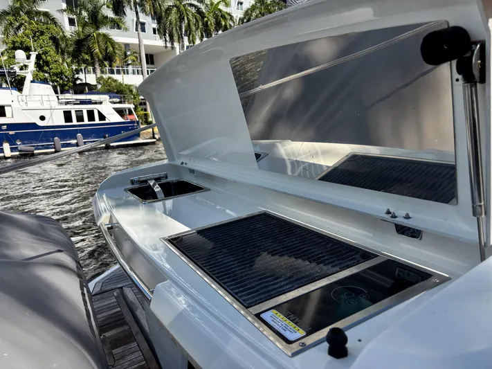 Micky's Dream Yacht Photos Pics Outdoor kitchen on 2020 Greenline 45 Fly yacht with grill and sink, docked by palm trees.