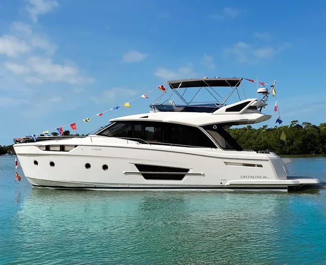 Micky's Dream Yacht Photos Pics 2020 Greenline 45 Fly yacht on calm water, decorated with colorful flags.