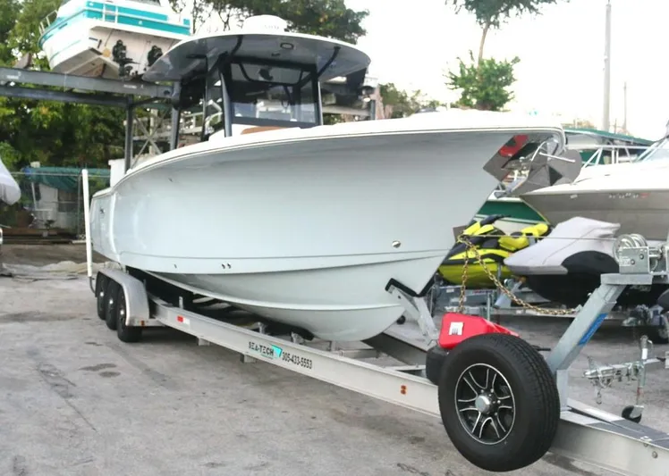  Yacht Photos Pics 2022 Sea Hunt Ultra 305 SE boat on trailer, parked outdoors.