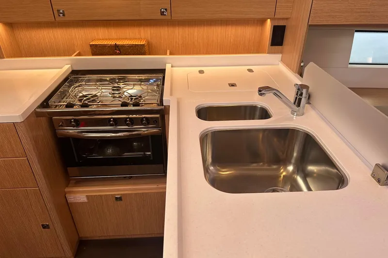 Dream Time Yacht Photos Pics Modern kitchen in 2022 Bavaria C45 yacht with stove, dual sinks, and wooden cabinetry.
