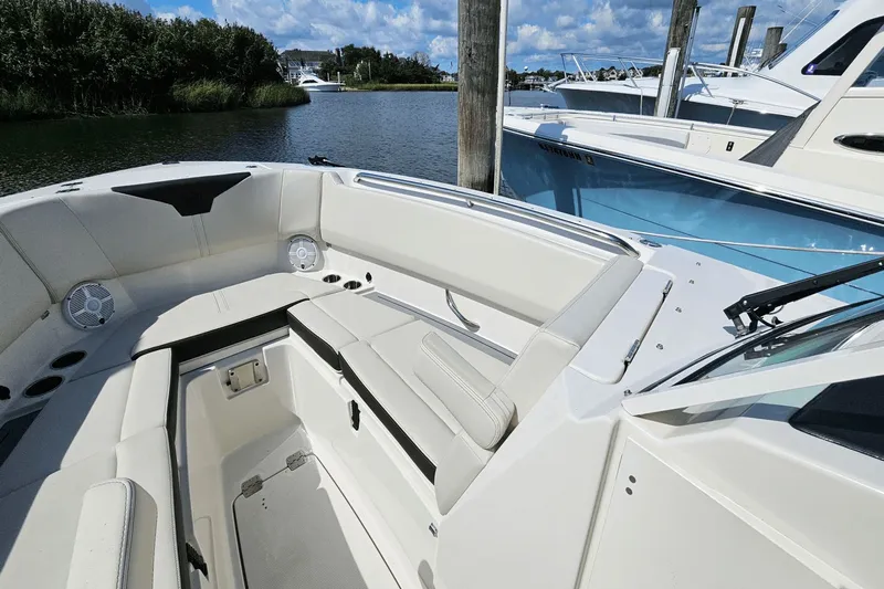  Yacht Photos Pics 2023 Sailfish 276 DC boat interior with white seating, docked by the water.