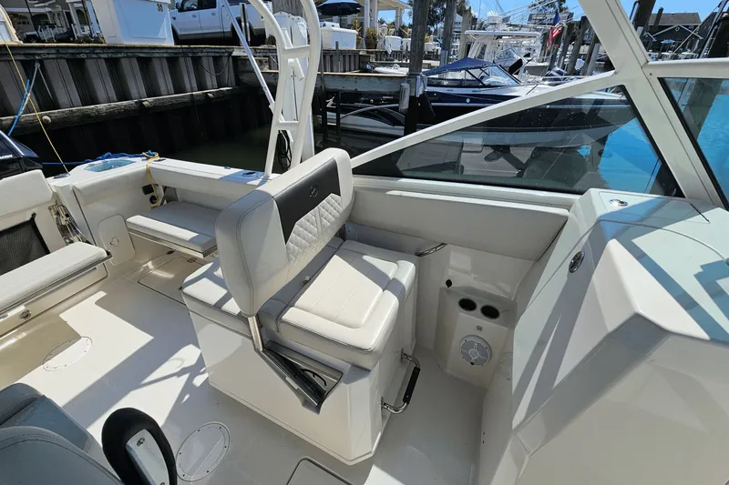  Yacht Photos Pics 2023 Sailfish 276 DC boat interior with seating and docked boats in the background.