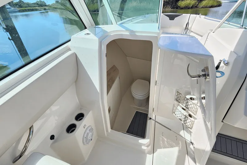  Yacht Photos Pics 2023 Sailfish 276 DC boat interior with compact bathroom and scenic water view.