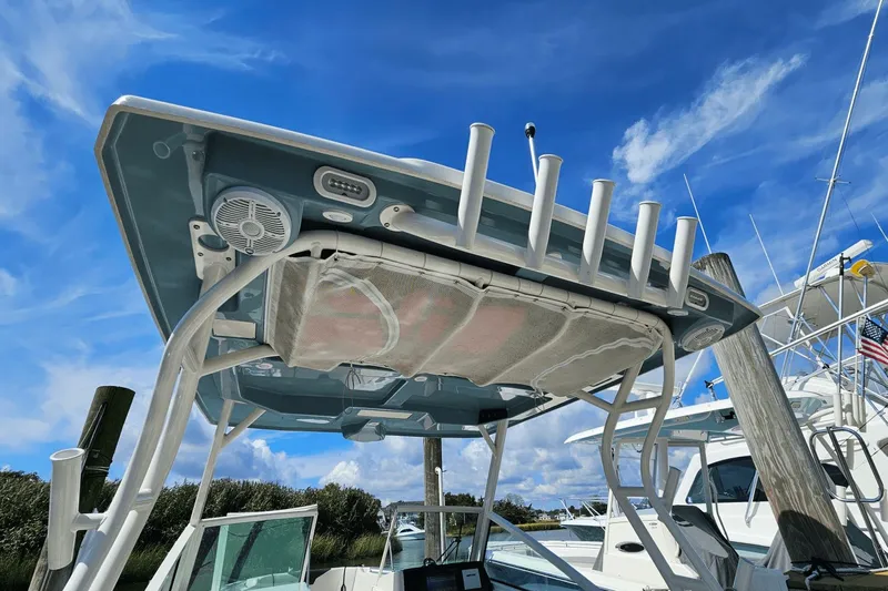  Yacht Photos Pics 2023 Sailfish 276 DC boat with rod holders and speakers under a clear blue sky.