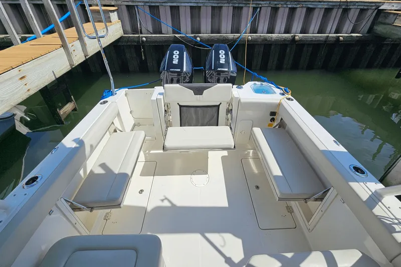  Yacht Photos Pics 2023 Sailfish 276 DC boat interior with seating and twin outboard motors at dock.