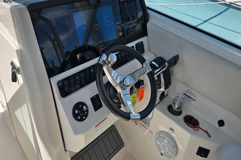  Yacht Photos Pics 2023 Sailfish 276 DC boat dashboard with steering wheel and control panel.
