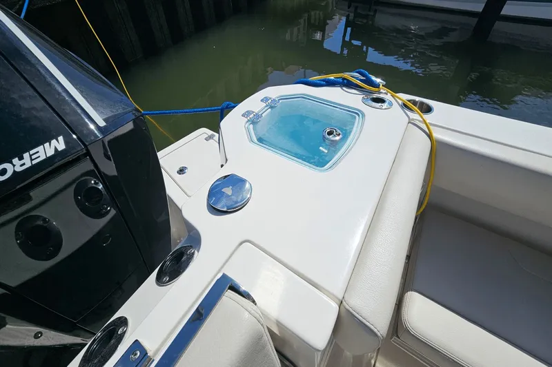  Yacht Photos Pics 2023 Sailfish 276 DC boat with livewell and Mercury engine, docked by the water.