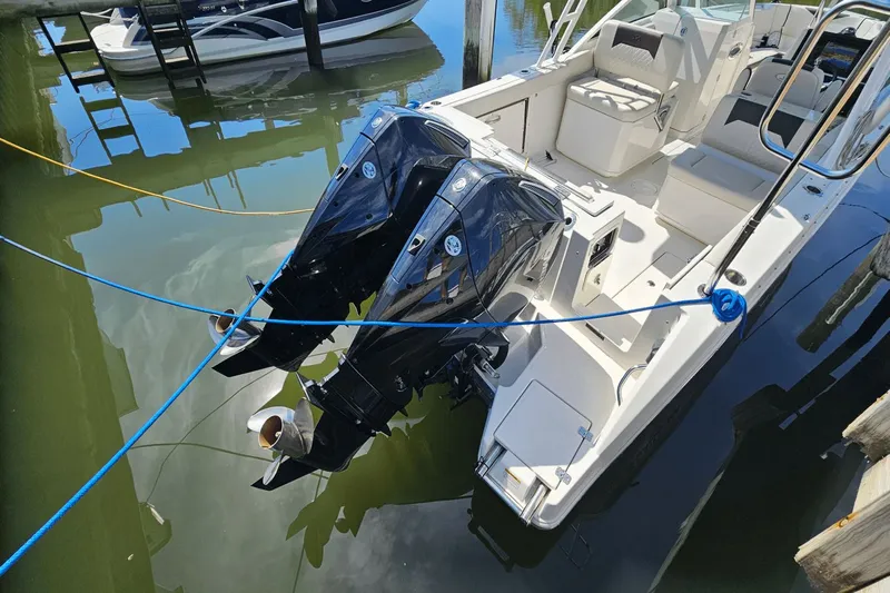  Yacht Photos Pics 2023 Sailfish 276 DC boat with dual outboard motors docked in marina.