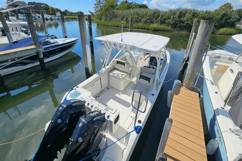  Yacht Photos Pics 2023 Sailfish 276 DC boat docked in a marina, featuring dual outboard motors.