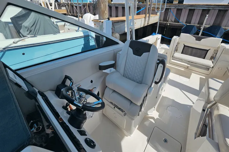  Yacht Photos Pics 2023 Sailfish 276 DC boat interior with steering wheel and seating.