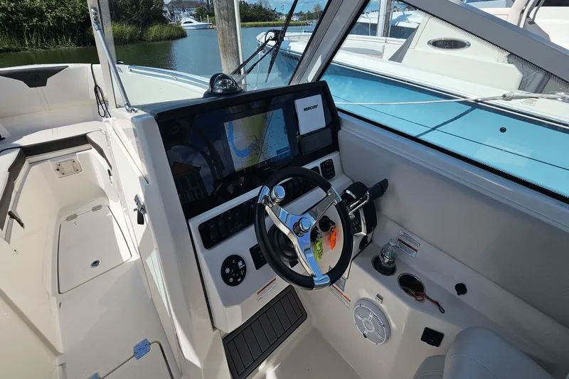  Yacht Photos Pics 2023 Sailfish 276 DC boat cockpit with steering wheel and navigation display.