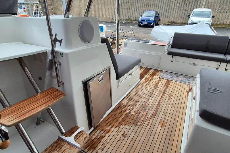  Yacht Photos Pics 2021 Fountaine Pajot Saona 47 yacht interior with teak flooring and cushioned seating.