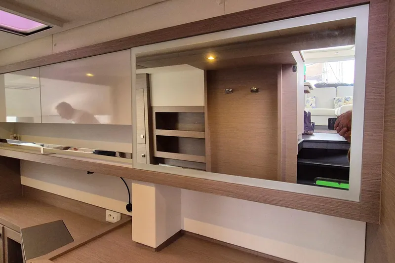  Yacht Photos Pics Interior of 2021 Fountaine Pajot Saona 47 yacht with modern wood finish and shelving.