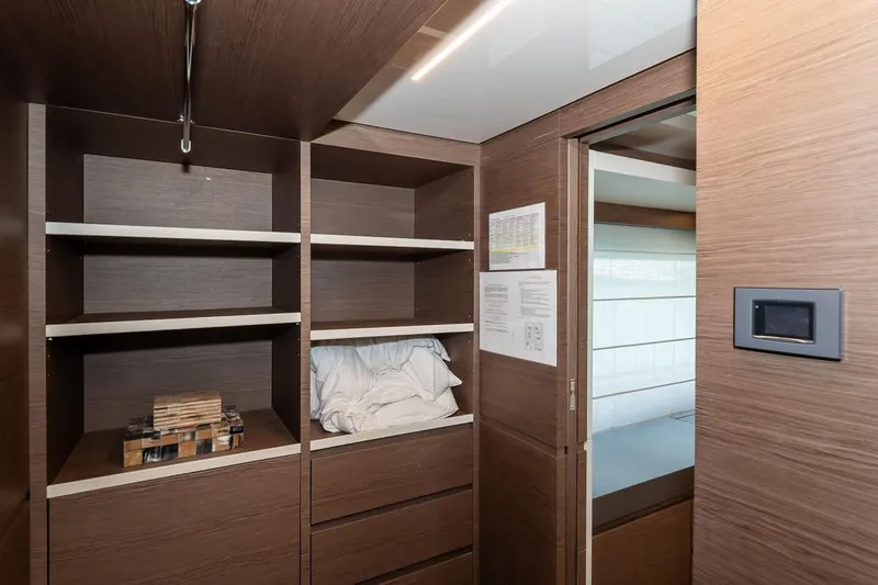 Willpower Yacht Photos Pics Wooden storage area inside 2018 FERETTI Navetta 37 yacht, featuring shelves and drawers.