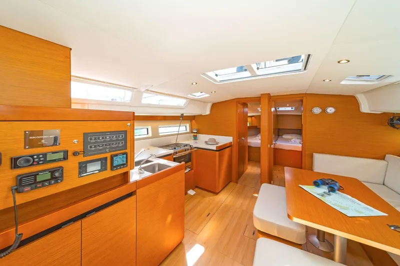  Yacht Photos Pics Interior of 2020 Jeanneau Sun Odyssey 490 yacht, featuring modern wood finish and navigation equipment.