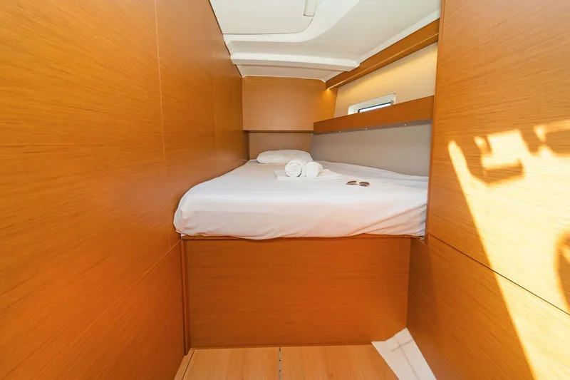  Yacht Photos Pics Cozy cabin interior of 2020 Jeanneau Sun Odyssey 490 yacht with wooden finish.