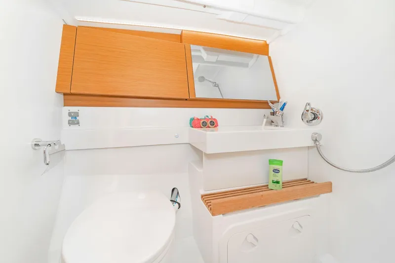  Yacht Photos Pics Modern bathroom in 2020 Jeanneau Sun Odyssey 490 yacht with wooden accents and sleek fixtures.