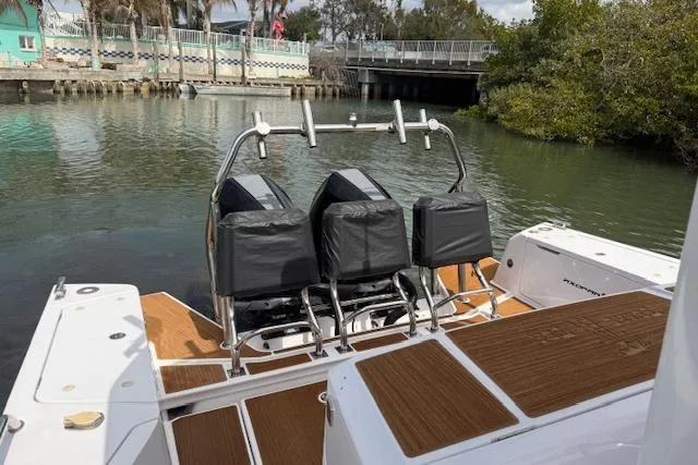  Yacht Photos Pics 2024 Axopar 37 Sun-Top boat with dual seats, docked near a bridge.