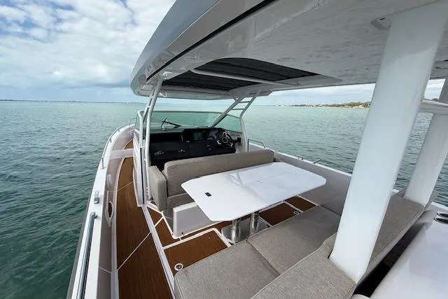  Yacht Photos Pics 2024 Axopar 37 Sun-Top boat with spacious seating and sleek design on calm waters.