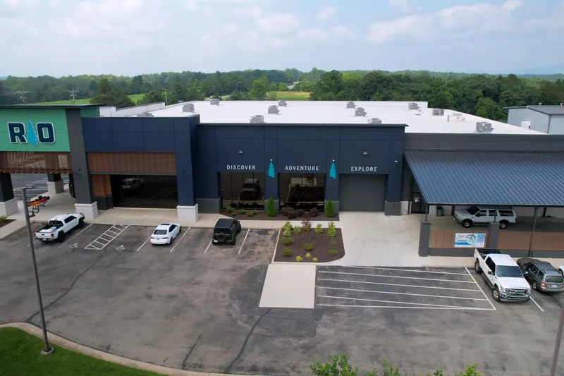  Yacht Photos Pics Aerial view of a modern commercial building with parking, surrounded by greenery.
