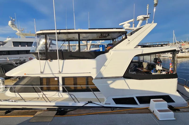 Outbound Yacht Photos Pics 1993 Symbol 55 Yachtfisher docked at marina, featuring sleek design and spacious upper deck.